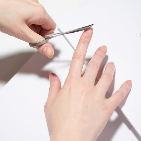 Anwendung einer TWEEZERMAN Nagelschere in silber am rechten Zeigefinger.