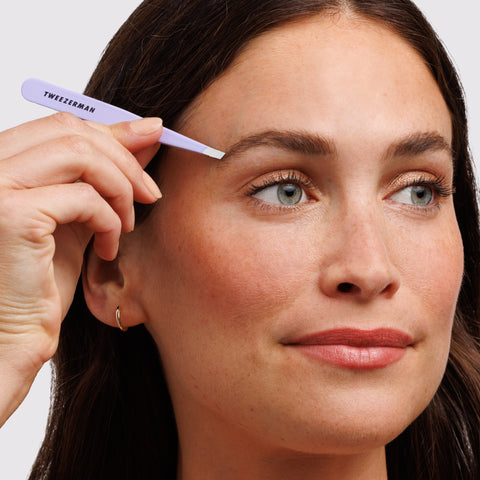 Anwendung einer TWEEZERMAN schrägen Pinzette in lavender an der rechten Augenbraue.