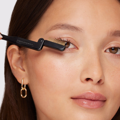 Anwendung eines TWEEZERMAN Wimpernkamms in schwarz am rechten Auge.