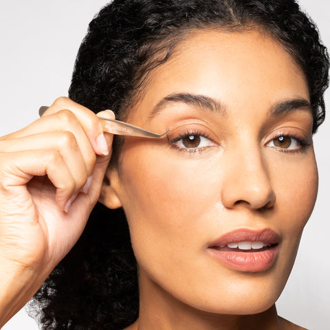 Anwendung eines TWEEZERMAN Wimpernapplikators an dem rechten Auge.