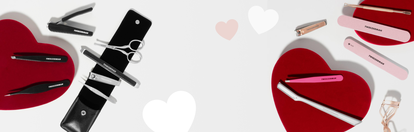Rote, weiße und rosa Herzen mit einer Auswahl an Tweezerman-Schönheitswerkzeugen zum Valentinstag.