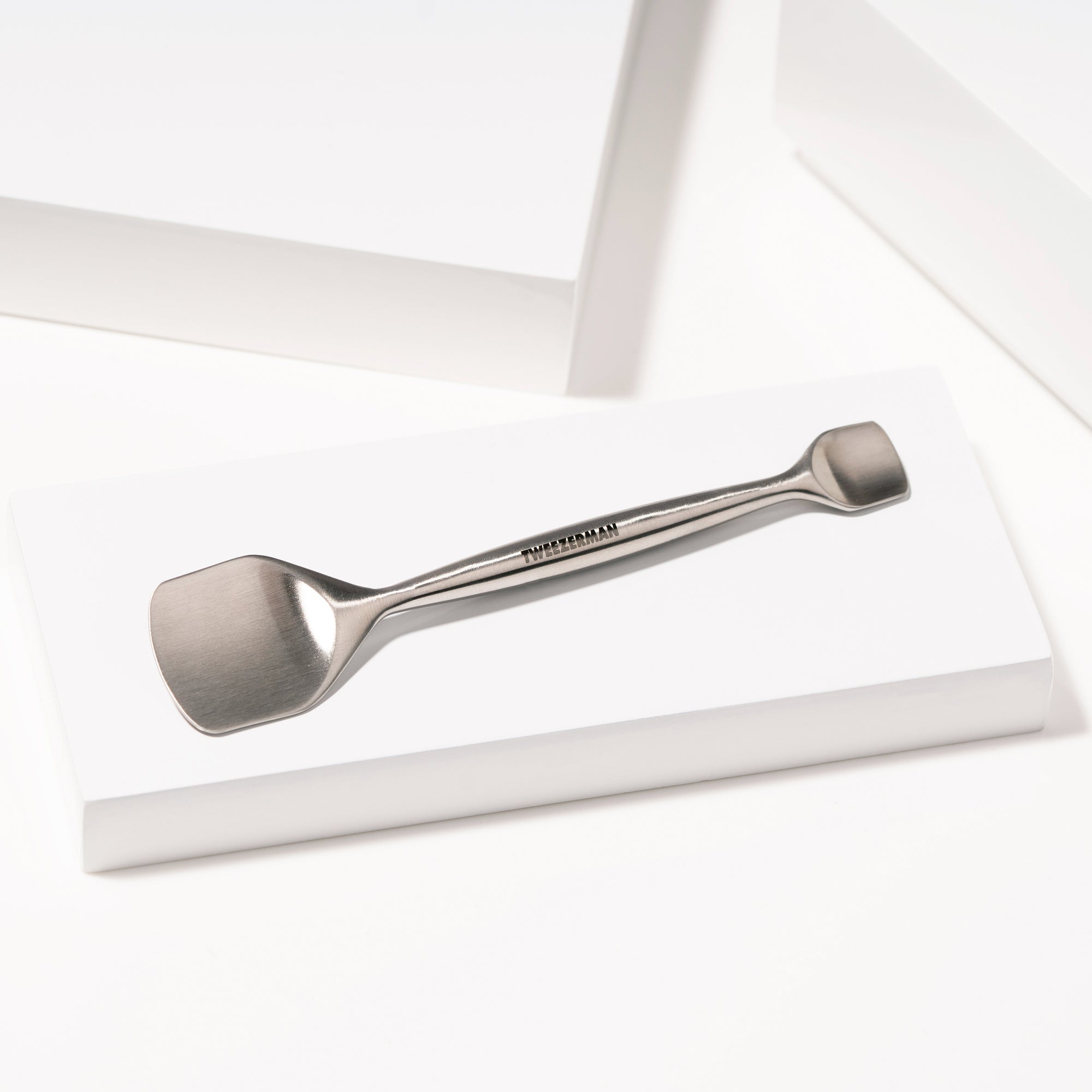 TWEEZERMAN Porenreiniger in silber aus rostfreiem Edelstahl auf weißen Podesten.