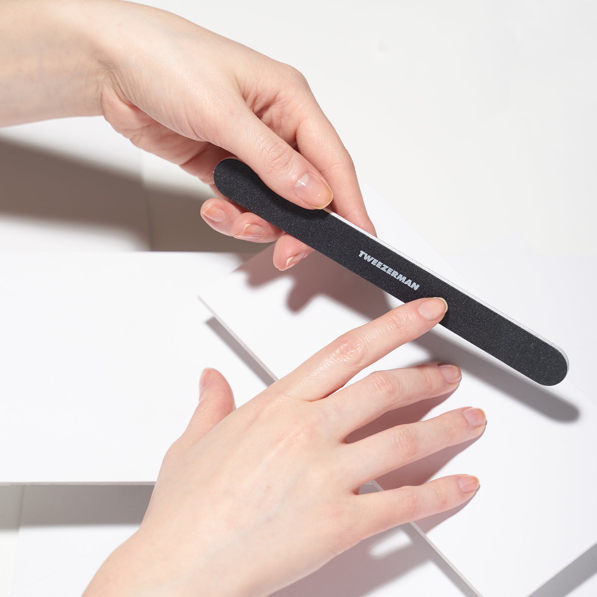 Anwendung einer TWEEZERMAN Nagelfeile in schwarz am rechten Zeigefinger.