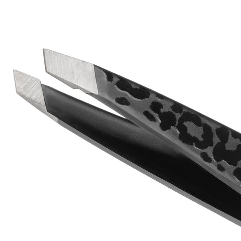 Nahaufnahme einer TWEEZERMAN Mini schrägen Pinzette in schwarz aus rostfreiem Edelstahl mit handgeschliffenen Spitzen und Leopardenmuster.