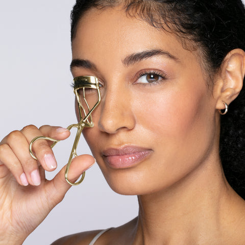 Anwendung einer TWEEZERMAN Wimpernzange in beige am rechten Auge.