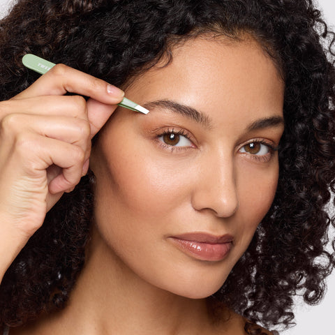 Anwendung einer TWEEZERMAN schrägen Pinzette in Pistachio an der rechten Augenbraue.