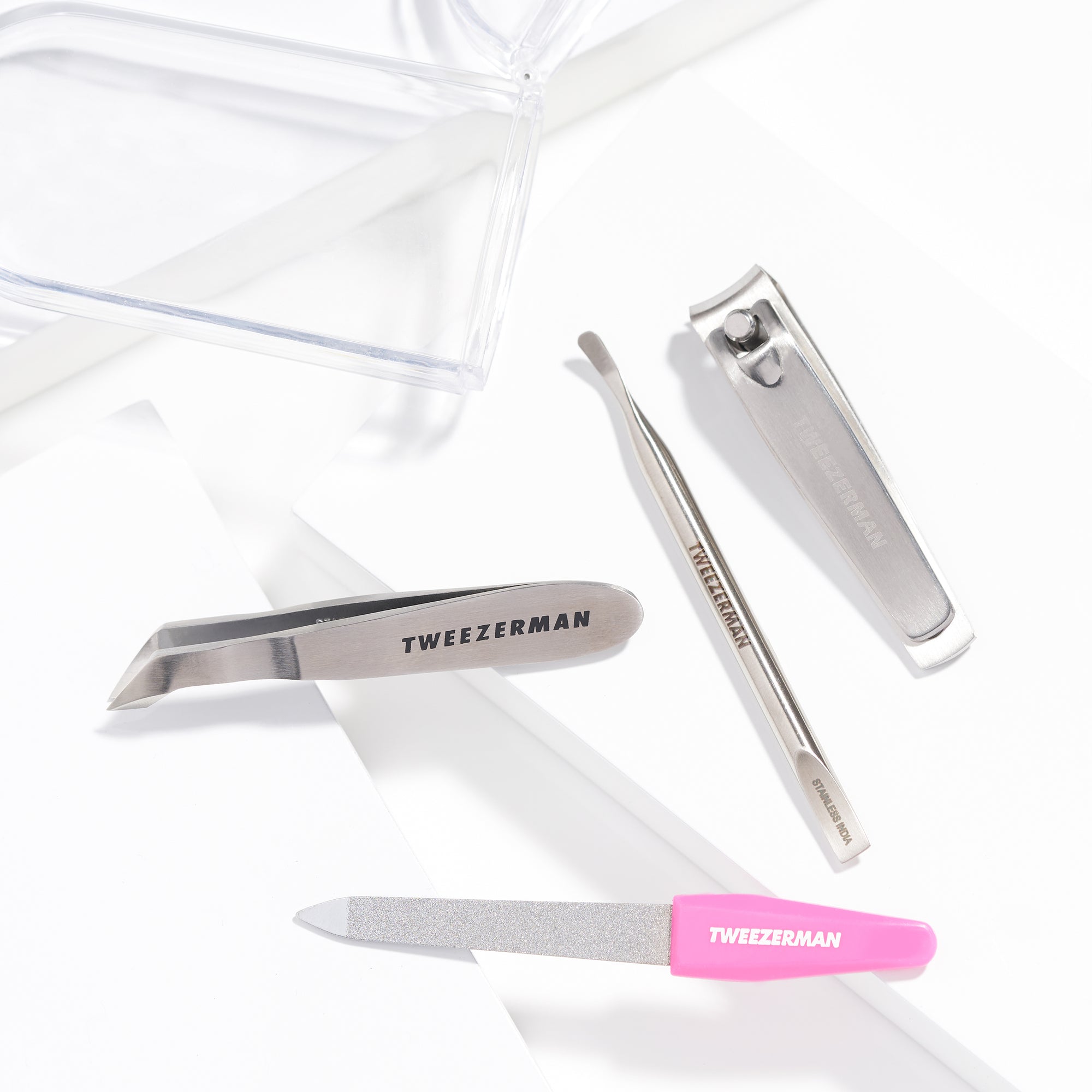 TWEEZERMAN 4teiliges Mini Set, mit diversen Produkten ideal für die Nagelpflege auf weißen Podesten.